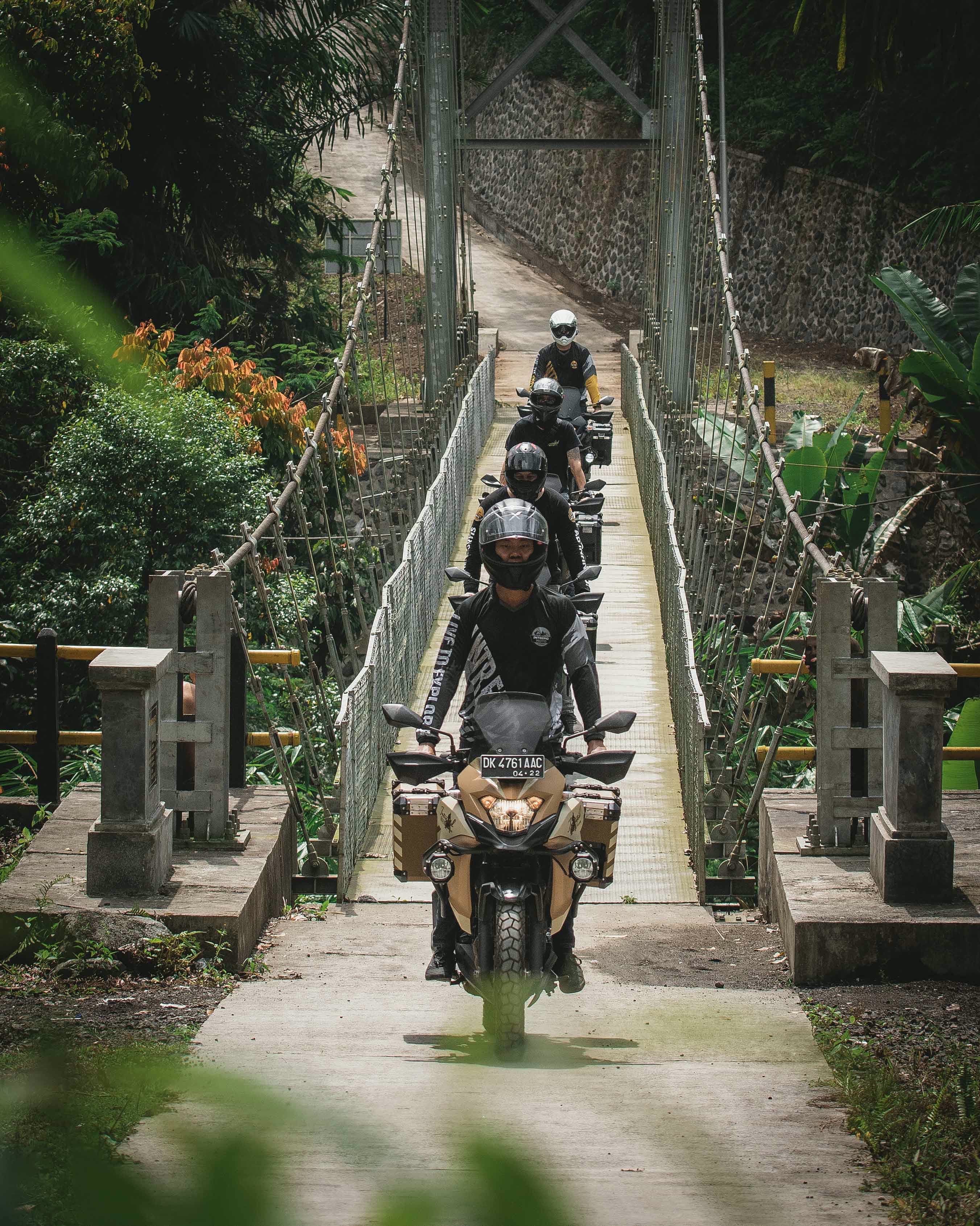 Riders crossing a suspension bridge